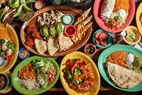 Tabletop arranged with a colorful Mexican meal.
