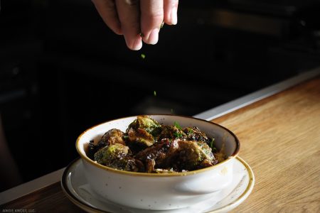 Crispy Brussel Sprouts Being Garnished by Hand