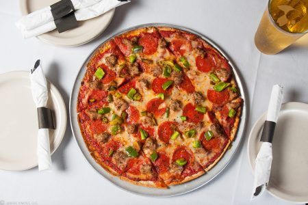 A pepperoni pizza on white tablecloth