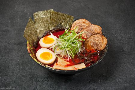 A bowl of spicy ramen with egg and seaweed