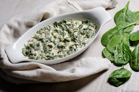 Individual serving of creamed spinach in oblong baking dish